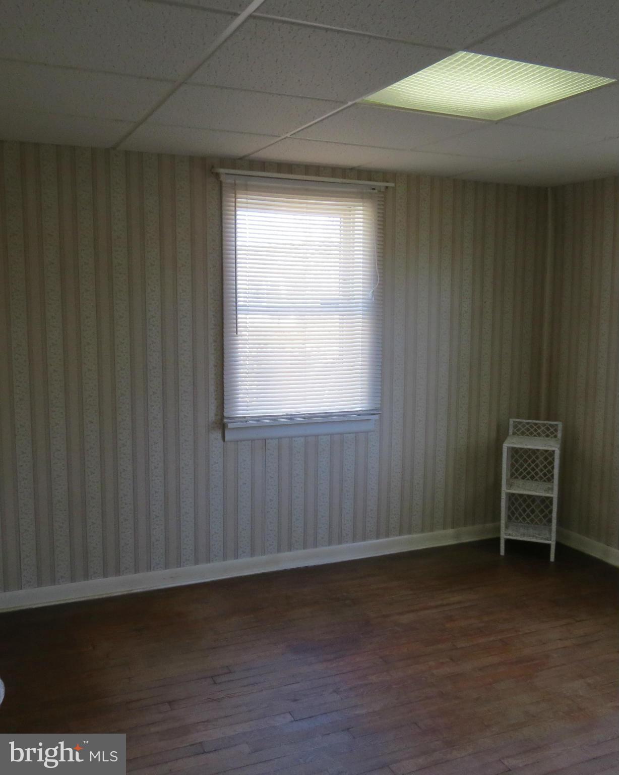 3401 Sollers Point Road Baltimore, MD 21222 - Photo 6 of 29 an empty room with wooden floor and windows