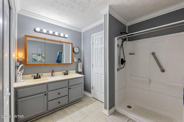 a bathroom with a double vanity sink mirror and shower