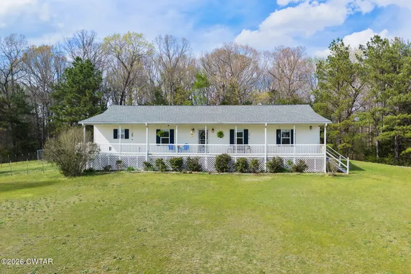 a view of a house with a yard and trees