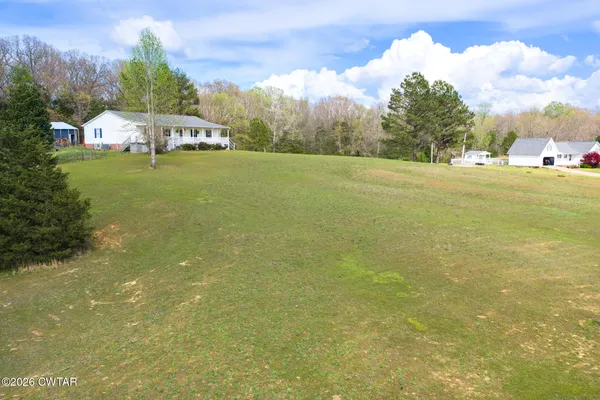 a view of yard with swimming pool and trees