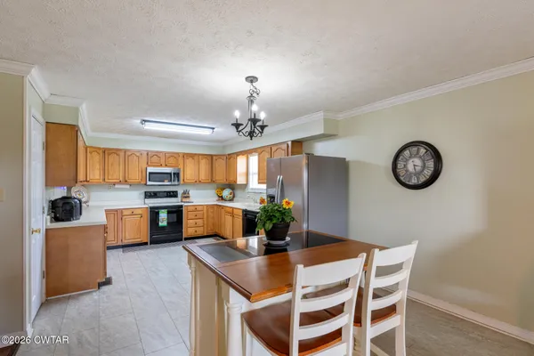 a view of a dining room and kitchen with a table chairs and a chandelier