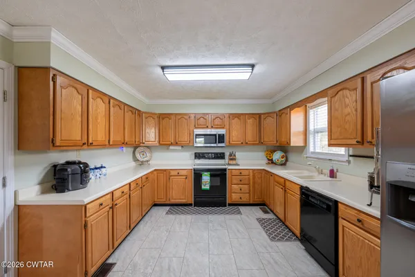 a kitchen with stainless steel appliances granite countertop sink a stove a sink dishwasher and cabinets with wooden floor