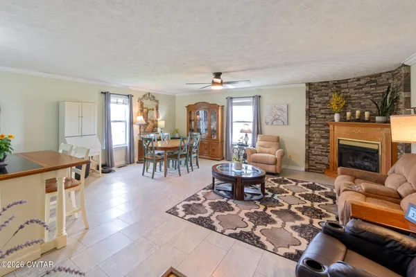 a living room with furniture a fireplace and a dining table with wooden floor