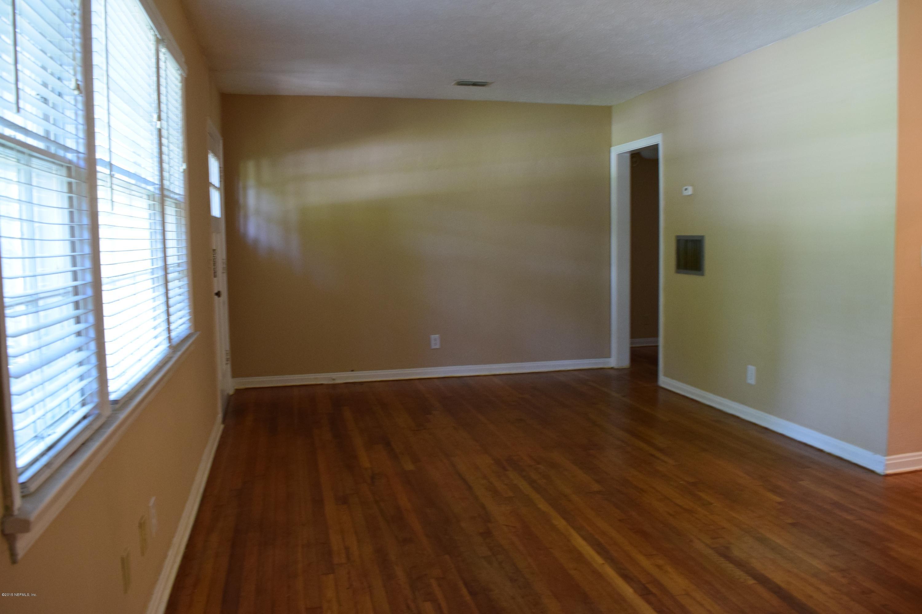 5604 Stetson Road Jacksonville, FL 32207 - Photo 4 of 18 a view of an empty room with wooden floor and a window