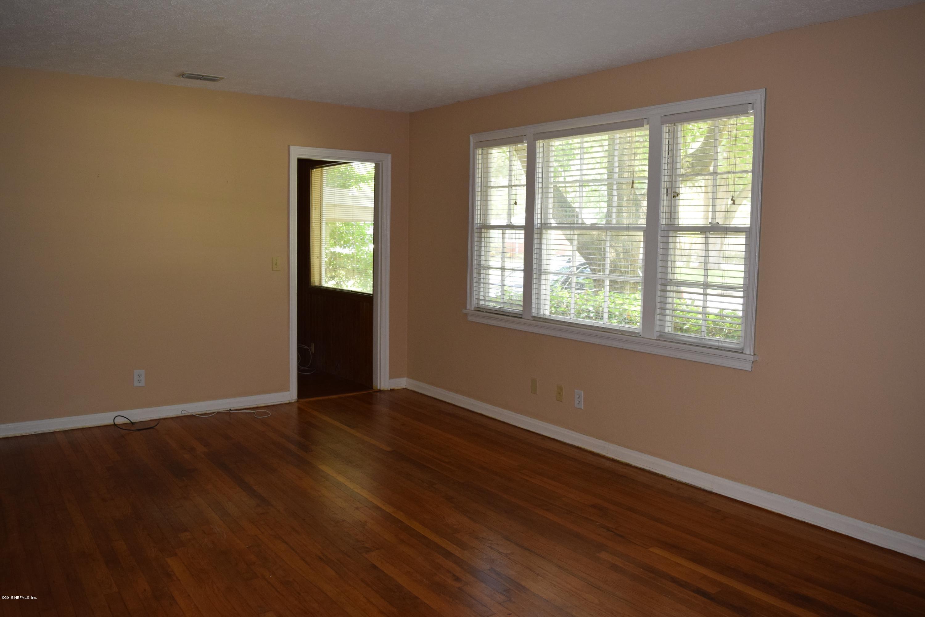 5604 Stetson Road Jacksonville, FL 32207 - Photo 5 of 18 a view of an empty room with wooden floor and a window