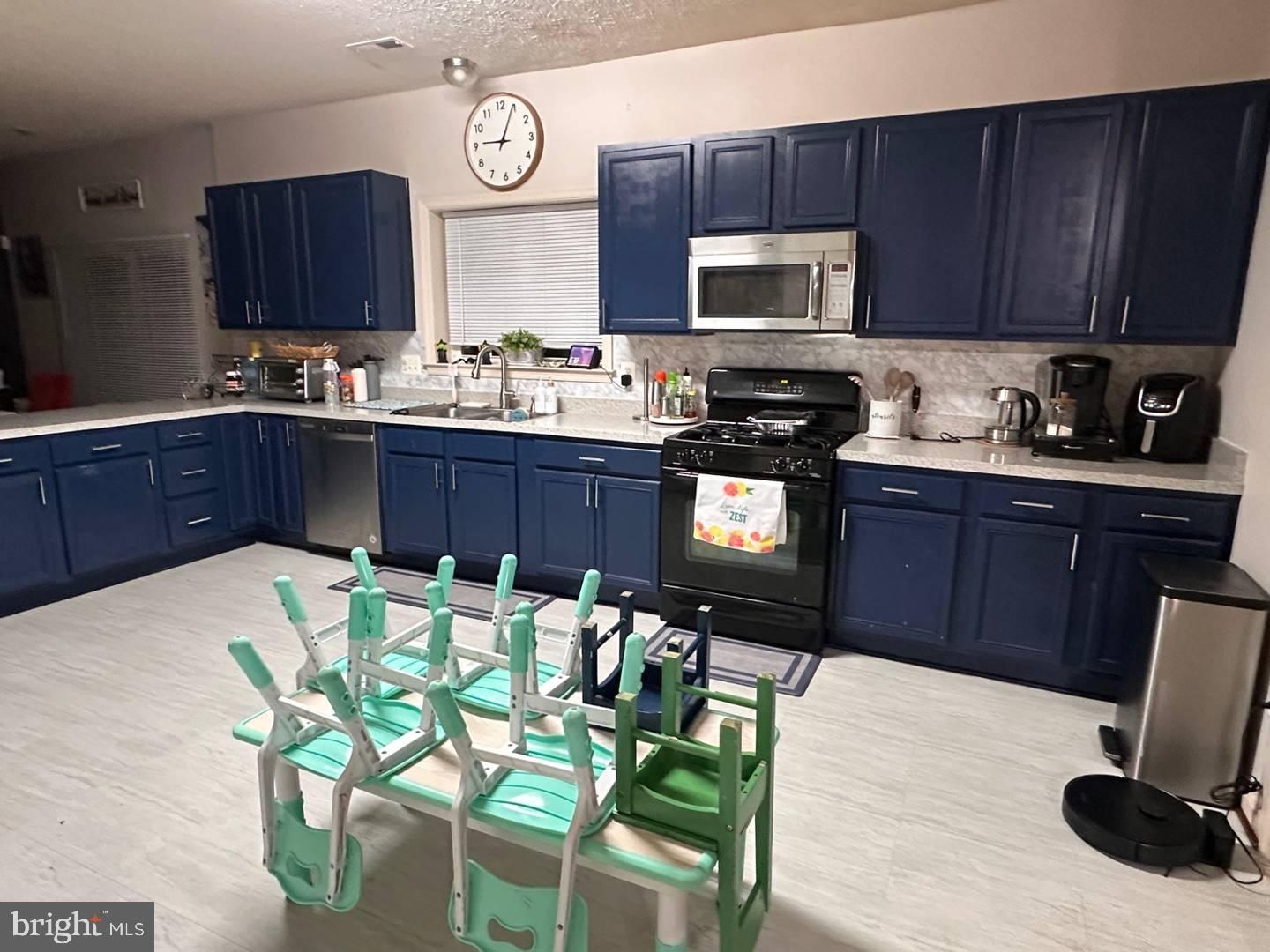 35391 Pheasant Ridge Road Locust Grove, VA 22508 - Photo 5 of 16 a kitchen with stainless steel appliances granite countertop a stove a sink dishwasher and a microwave with wooden cabinets