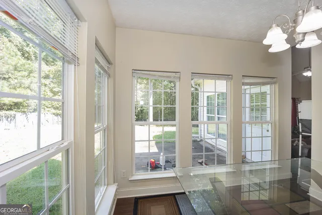 a living room filled with furniture and large windows