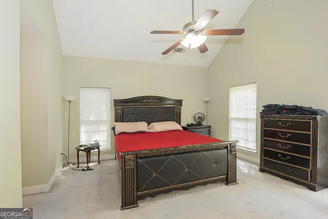 a bedroom with a bed and a ceiling fan