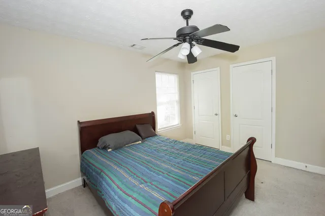 a bedroom with a bed and a ceiling fan