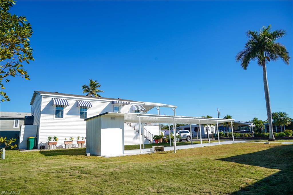 777 Walkerbilt Road Naples, FL 34110 - Photo 5 of 12 a front view of a building with a garden