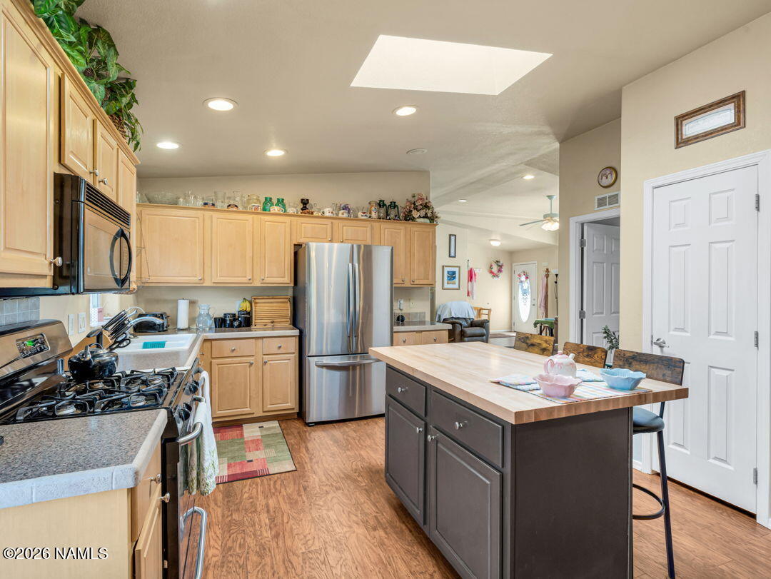 7538 Iron Buffalo Road Williams, AZ 86046 - Photo 10 of 30 a kitchen with a refrigerator a sink dishwasher and a stove with wooden floor