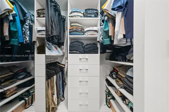 a view of walk in closet with clothes and shoes
