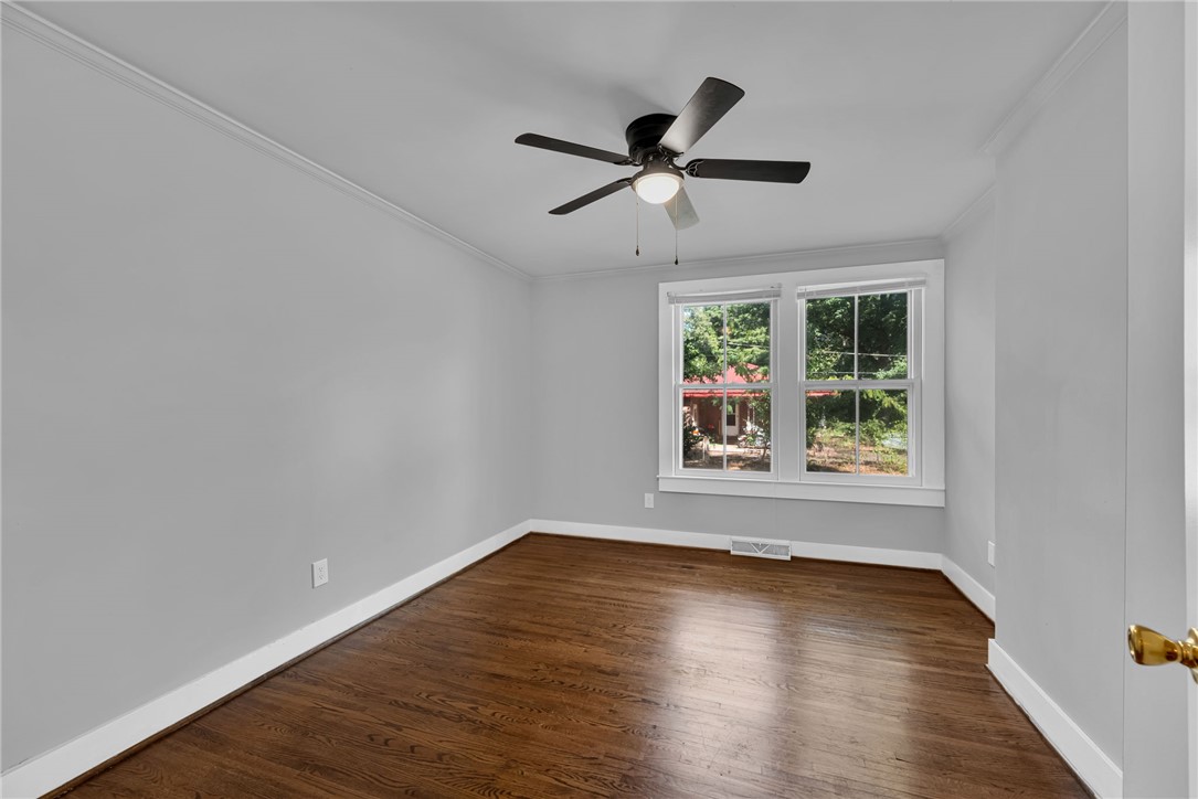 403 Lewis Street Anderson, SC 29624 - Photo 17 of 35 Polished hardwood floors and classic crown molding elevate this versatile room.