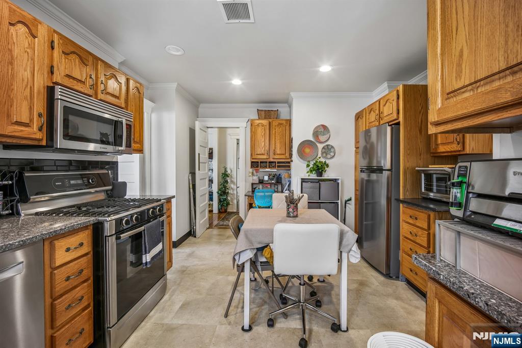 57 Union Street, Unit C4021 Montclair, NJ 07042 - Photo 12 of 20 a kitchen with stainless steel appliances granite countertop a stove top oven a sink a dining table and chairs