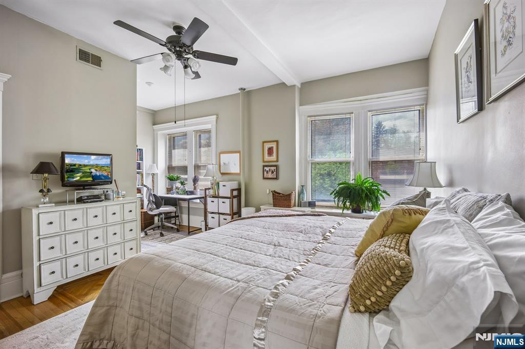 57 Union Street, Unit C4021 Montclair, NJ 07042 - Photo 20 of 20 a bed sitting in a bedroom next to a window with a flat screen tv