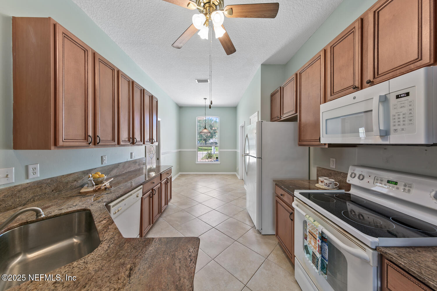 9317 Beresford Court Jacksonville, FL 32244 - Photo 15 of 55 a kitchen with granite countertop a stove sink and cabinets