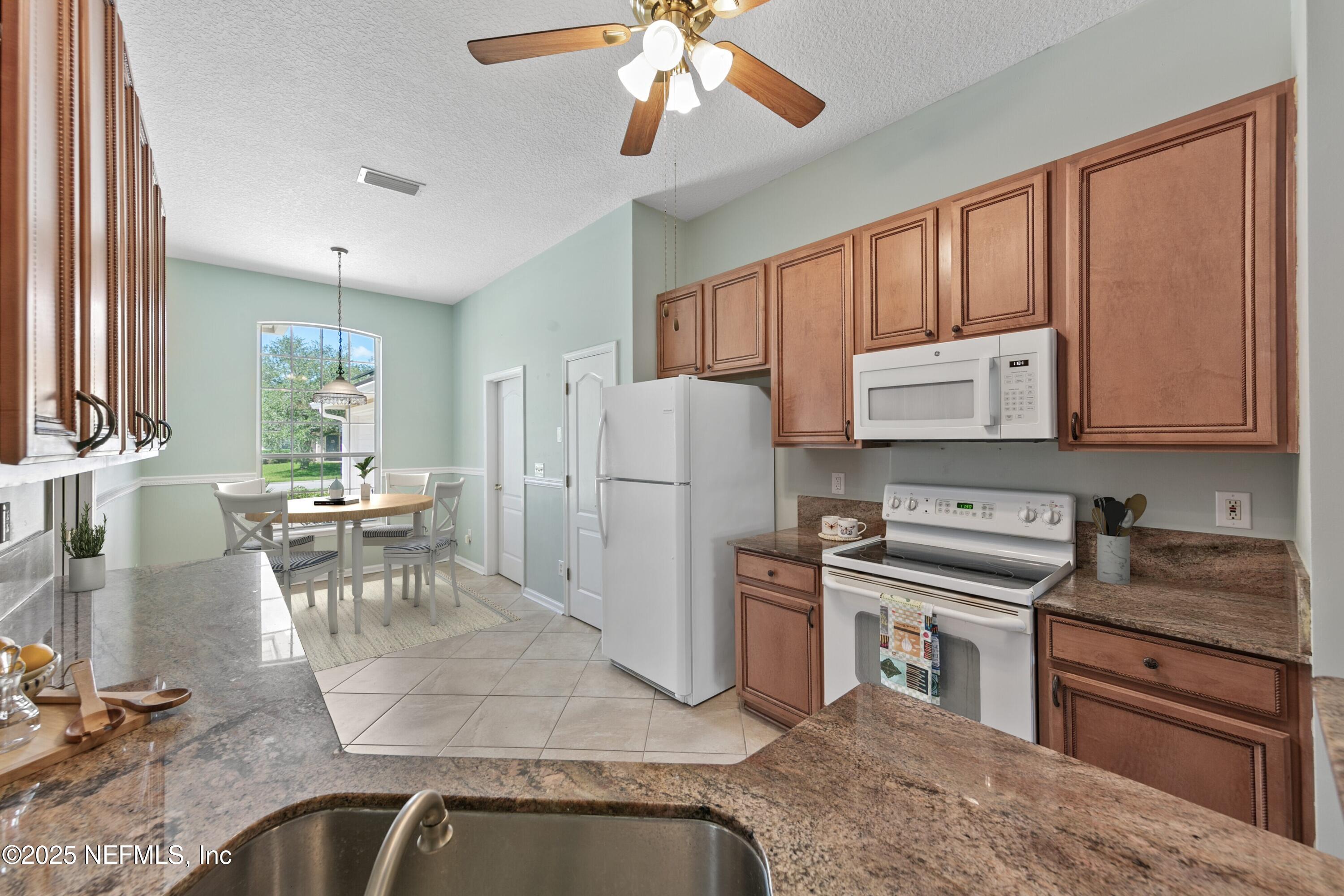 9317 Beresford Court Jacksonville, FL 32244 - Photo 19 of 55 a kitchen with stainless steel appliances granite countertop a refrigerator stove and sink