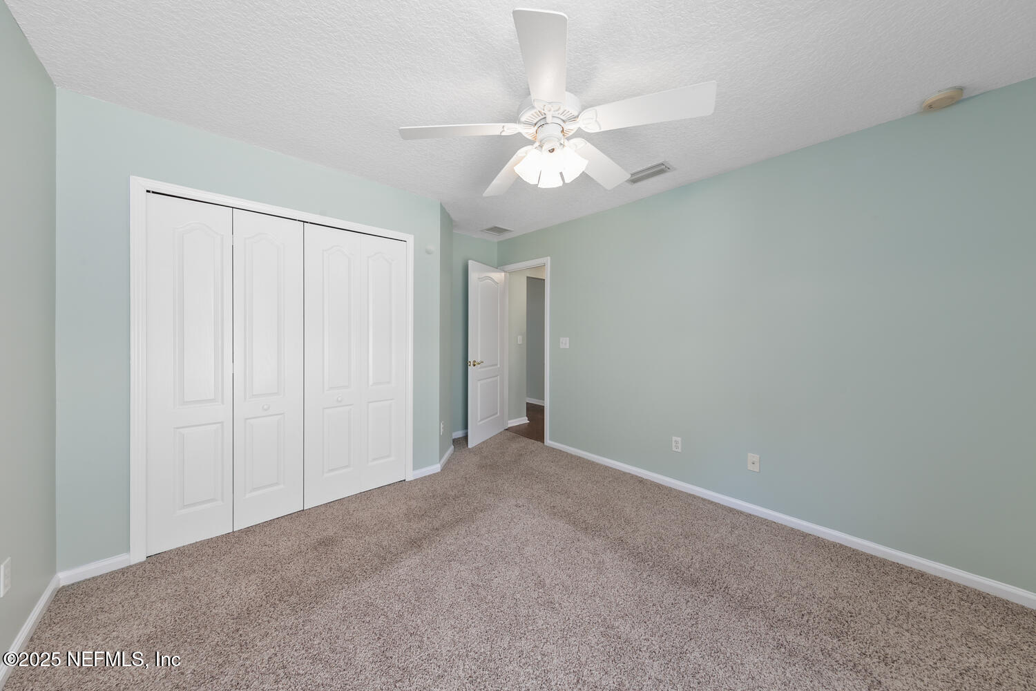 9317 Beresford Court Jacksonville, FL 32244 - Photo 31 of 55 an empty room with a chandelier fan and closet area
