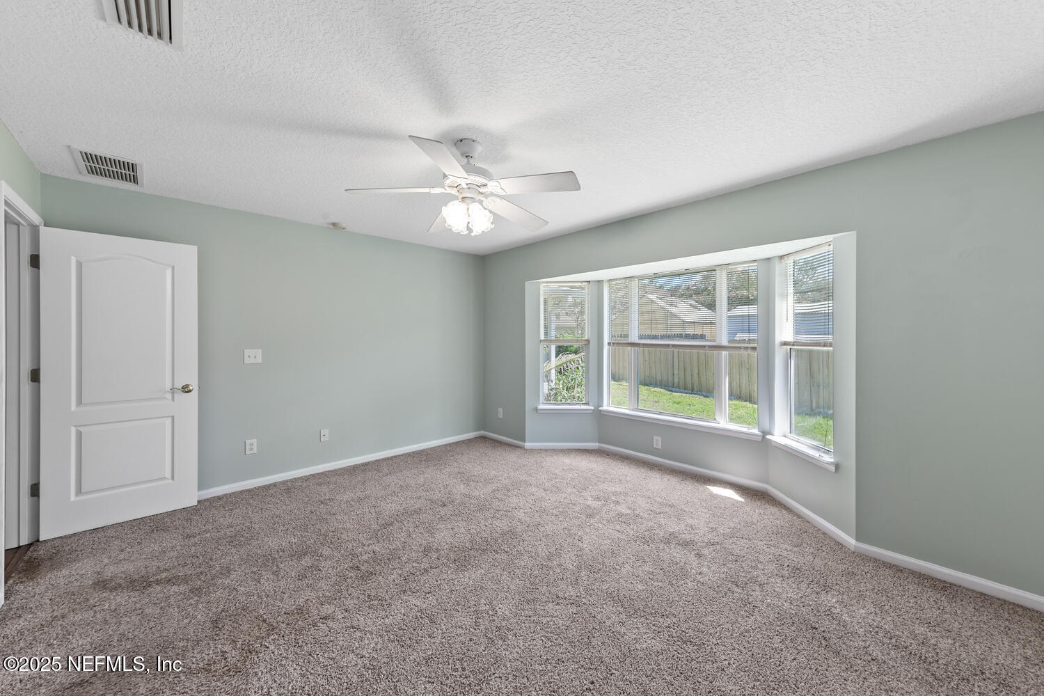 9317 Beresford Court Jacksonville, FL 32244 - Photo 37 of 55 an empty room with windows and ceiling fan