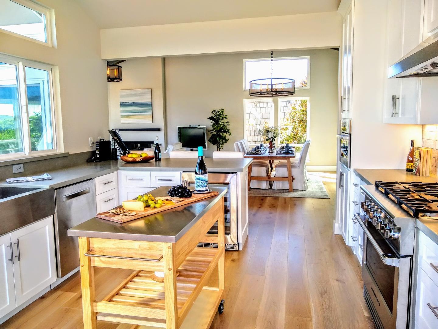 150 Vía Soderini Aptos, CA 95003 - Photo 5 of 36 a kitchen with stainless steel appliances a stove a sink dishwasher and a dining table with wooden floor