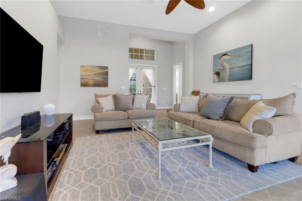 6757 Bent Grass Drive Naples, FL 34113 - Photo 4 of 27 a living room with furniture and a flat screen tv