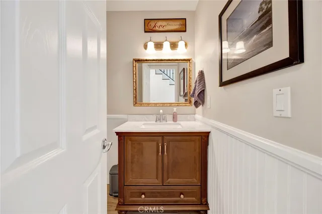 a bathroom with a toilet sink vanity and mirror