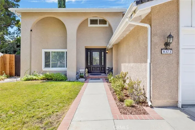 a living room with furniture a wooden floor and a ceiling fan