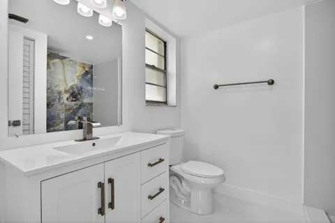 a bathroom with a toilet sink and mirror
