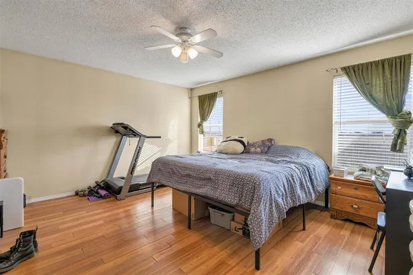 a bedroom with a bed and wooden floor