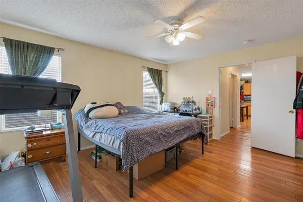 a bedroom with a bed a table and wooden floor