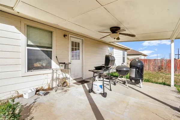 a view of a patio with a table and chairs and floor to ceiling window