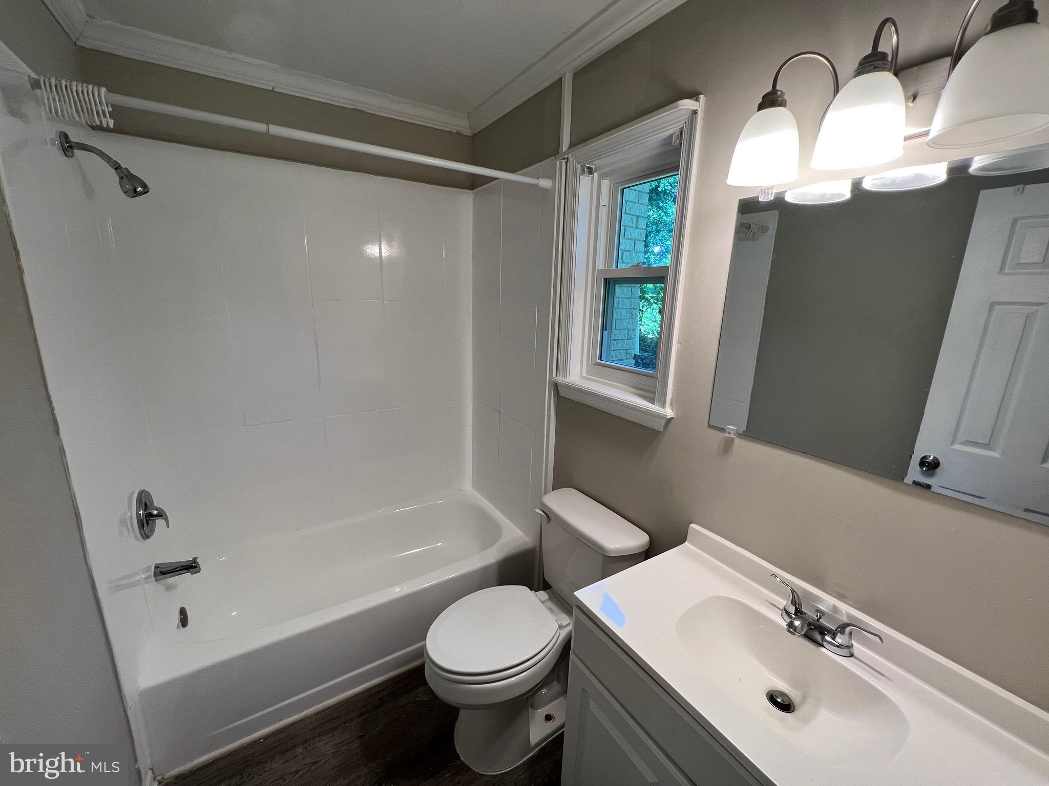 18402 Cedar Drive, Unit A Triangle, VA 22172 - Photo 6 of 9 a bathroom with a sink toilet mirror and shower
