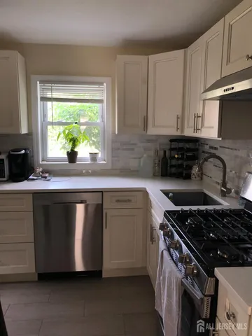 a kitchen with granite countertop a sink stove and cabinets