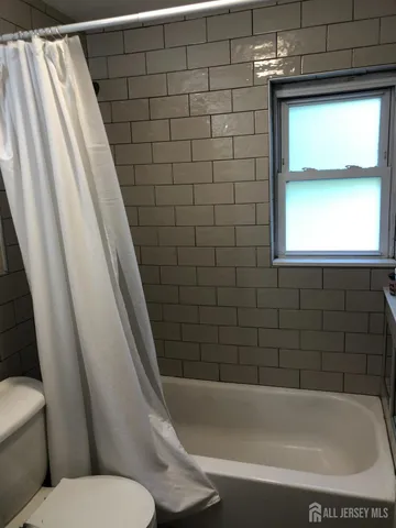 a bathroom with a toilet and bathtub