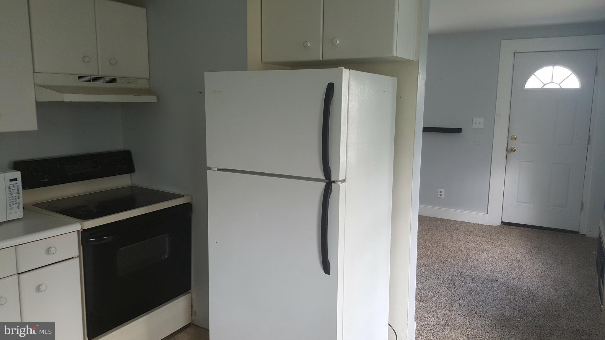 302 3rd Street Chesapeake City, MD 21915 - Photo 3 of 9 a kitchen with a refrigerator and cabinets