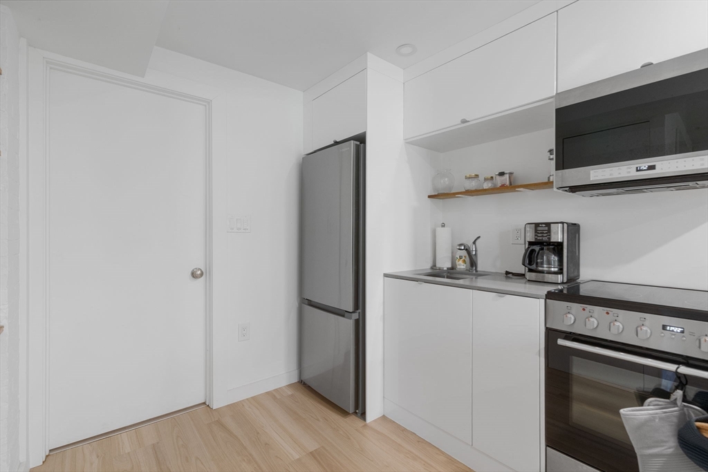 99 Upland Road Cambridge, MA 02140 - Photo 6 of 16 a kitchen with stainless steel appliances a refrigerator and a stove top oven