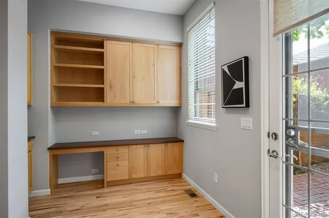 a view of hallway with walk in closet and wooden floor