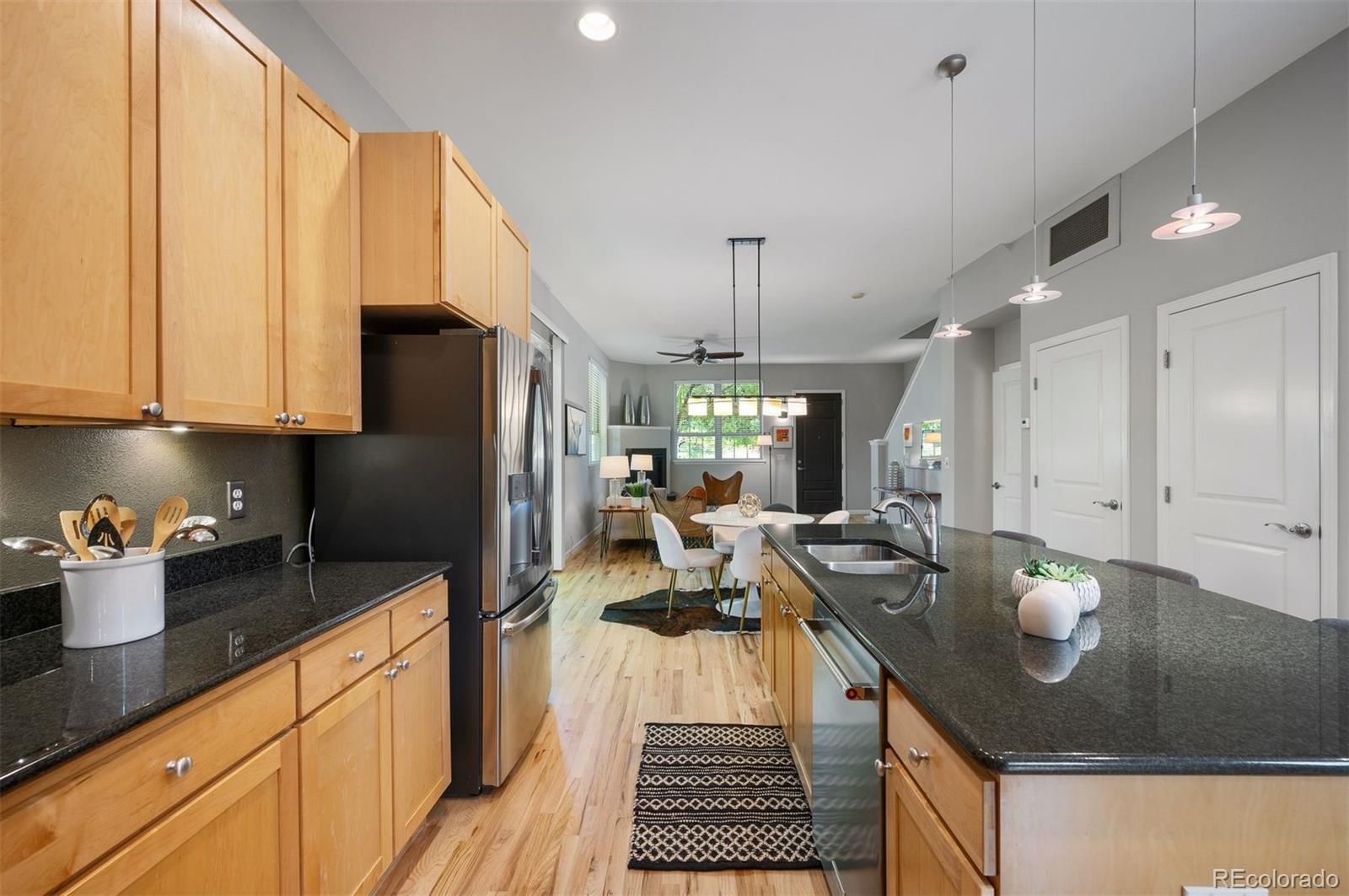 217 Spruce Street, Unit 101 Denver, CO 80230 - Photo 12 of 37 a kitchen with sink refrigerator and cabinets