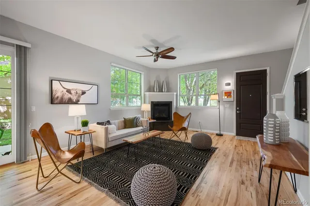 a living room with furniture two window and a fireplace