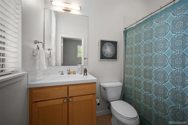 a bathroom with a toilet sink vanity and mirror
