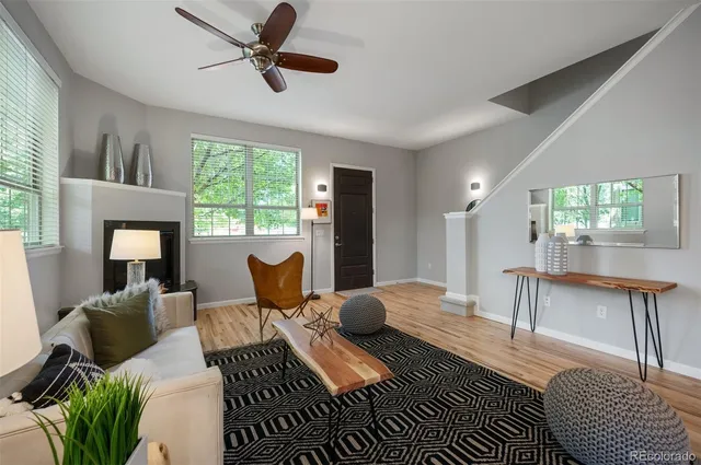 a living room with furniture a large window and wooden floor