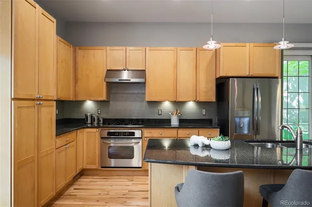 a kitchen with granite countertop a stove and a refrigerator
