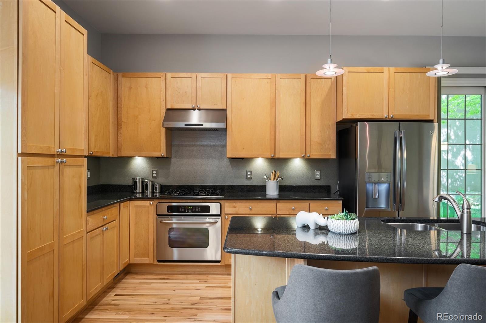 217 Spruce Street, Unit 101 Denver, CO 80230 - Photo 10 of 37 a kitchen with granite countertop a stove and a refrigerator