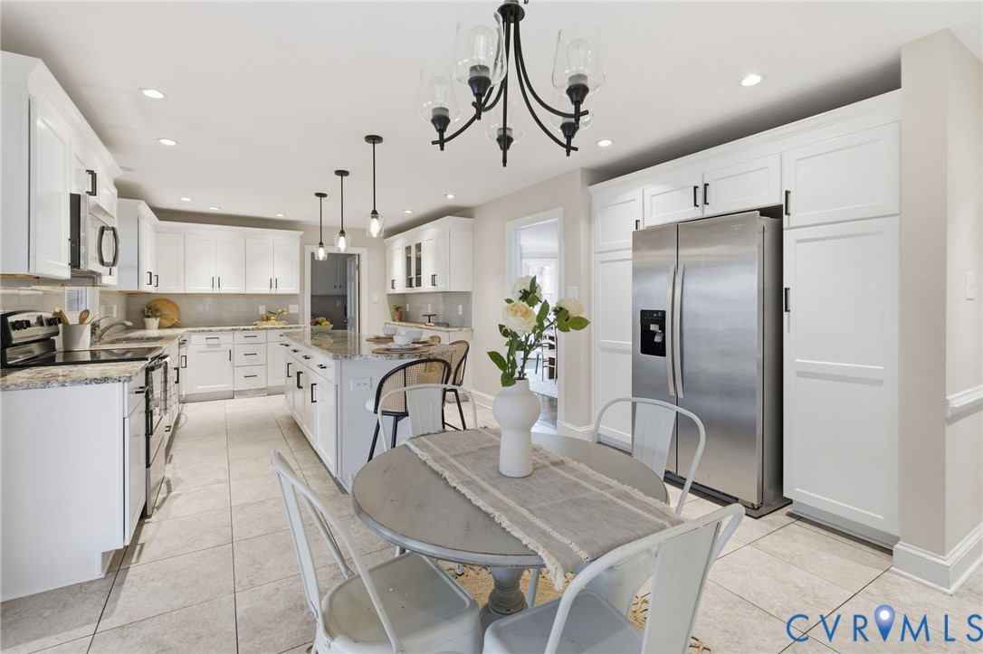 6024 Watch Harbour Road Midlothian, VA 23112 - Photo 11 of 44 a kitchen with stainless steel appliances granite countertop a refrigerator a stove a sink dishwasher and white cabinets with wooden floor