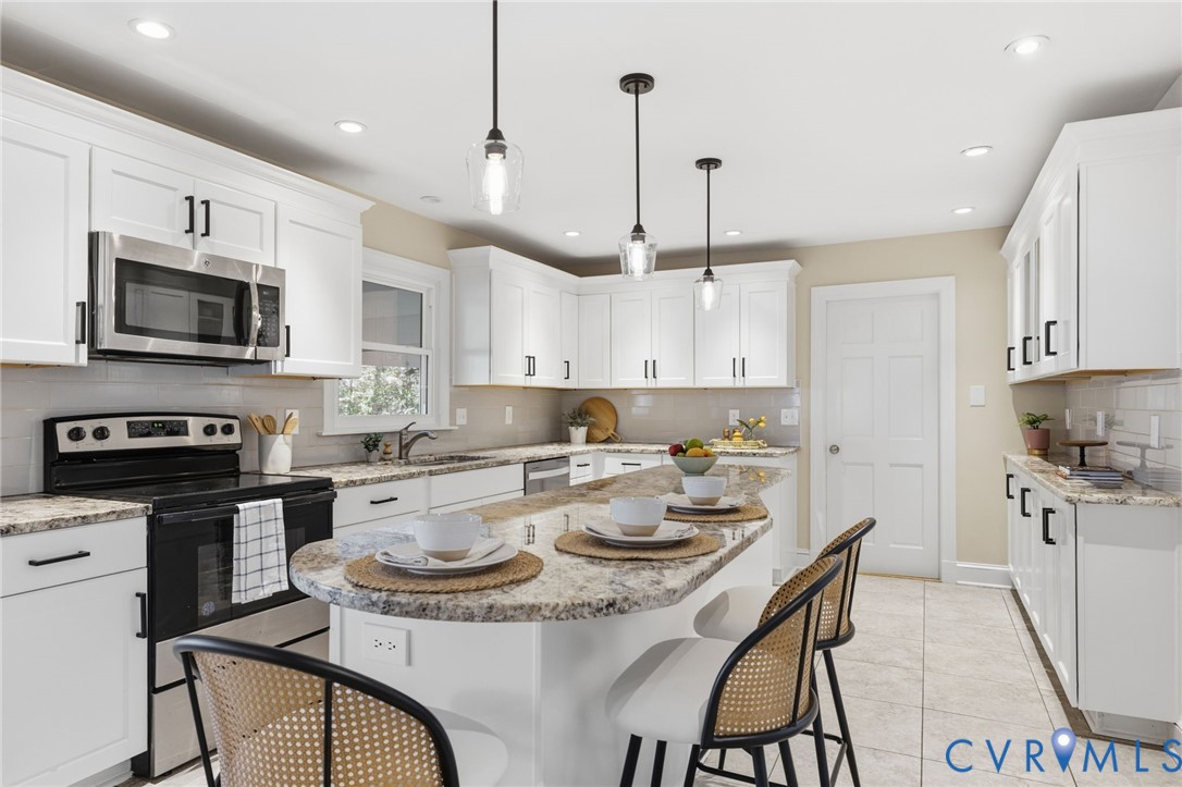 6024 Watch Harbour Road Midlothian, VA 23112 - Photo 6 of 44 a kitchen with a stove a sink a dining table and chairs