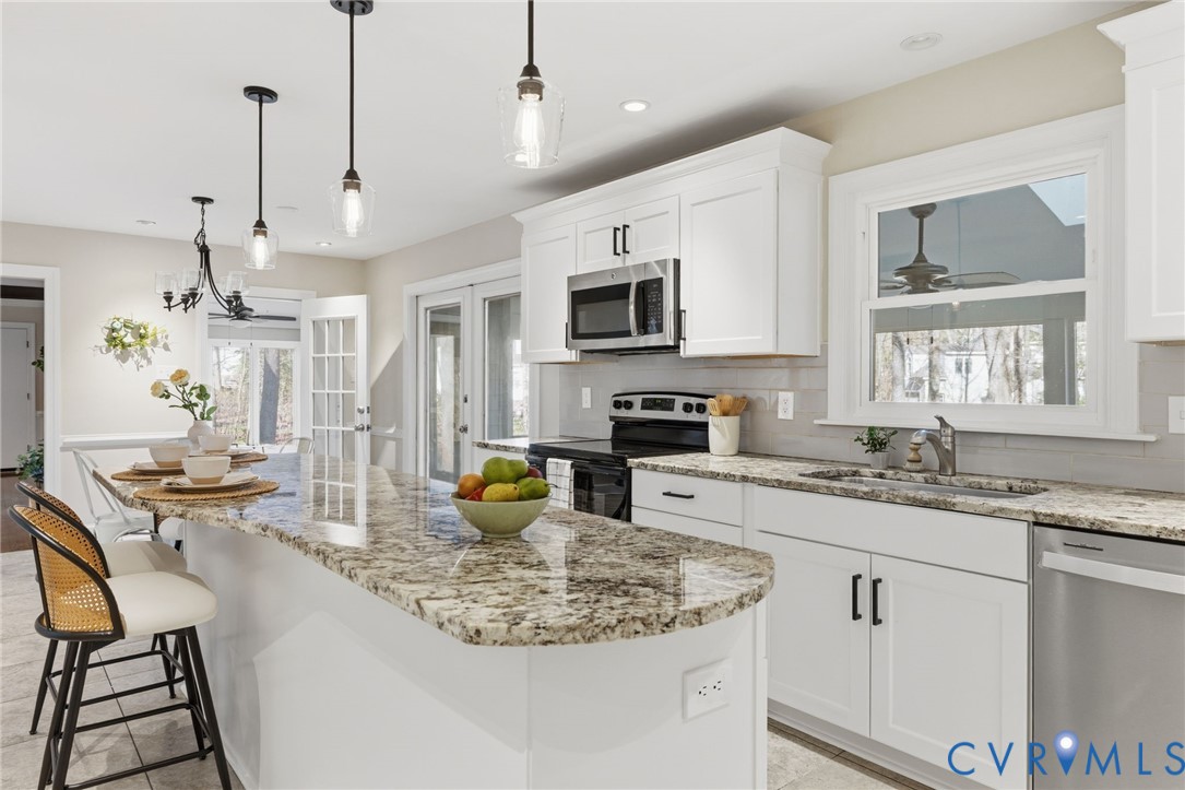 6024 Watch Harbour Road Midlothian, VA 23112 - Photo 8 of 44 a kitchen with stainless steel appliances granite countertop a stove a sink a microwave a dining table and chairs