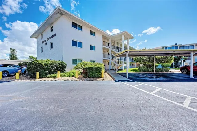 a view of a blue house with a yard and potted plants