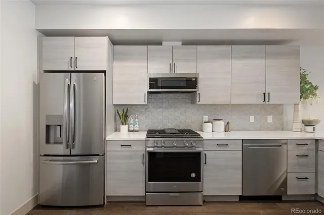 a kitchen with stainless steel appliances a stove cabinets and wooden floor