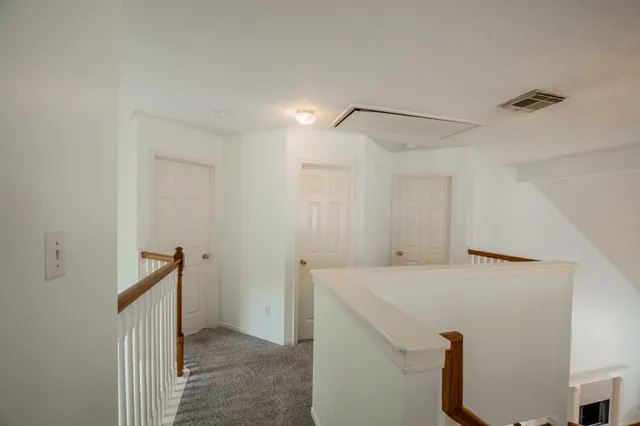 a view of staircase with railing and white walls