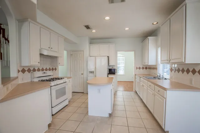 a large kitchen with stainless steel appliances granite countertop a stove and a sink